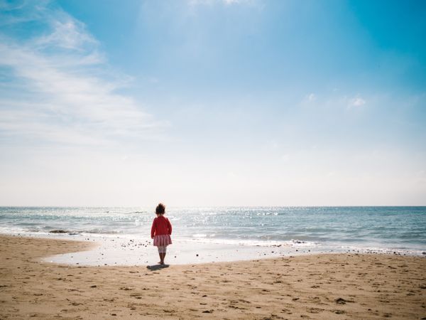 Girl walking on beach in sunny day
