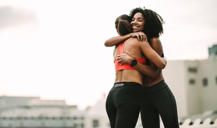 Fitness women embracing each other in joy after workout