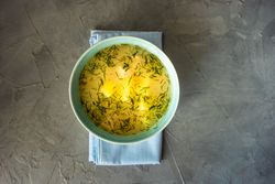 Bowl of healthy chicken soup on napkin with copy space