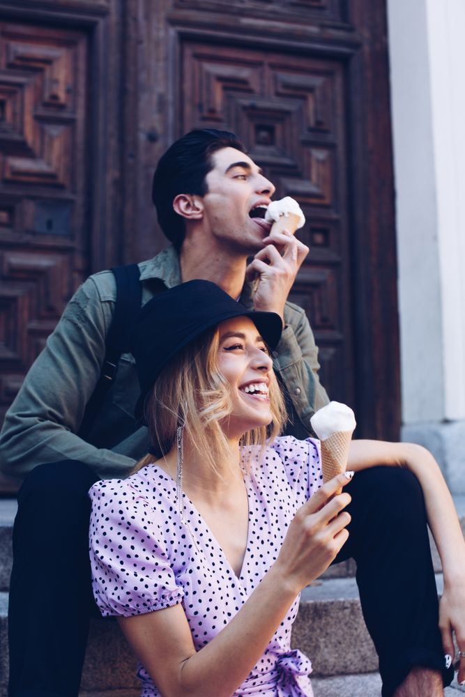 Happy couple feeding each other by ice cream