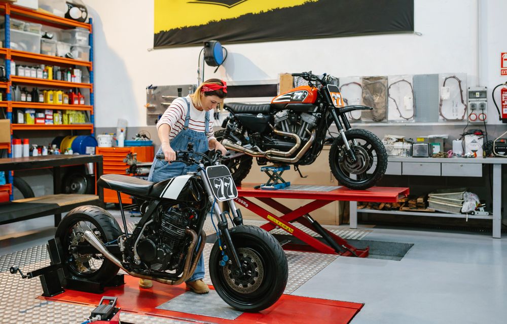 Mechanic woman placing custom motorcycle over platform