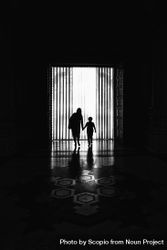 Mother hold her child's hand walking in hallway in grayscale bekZE5