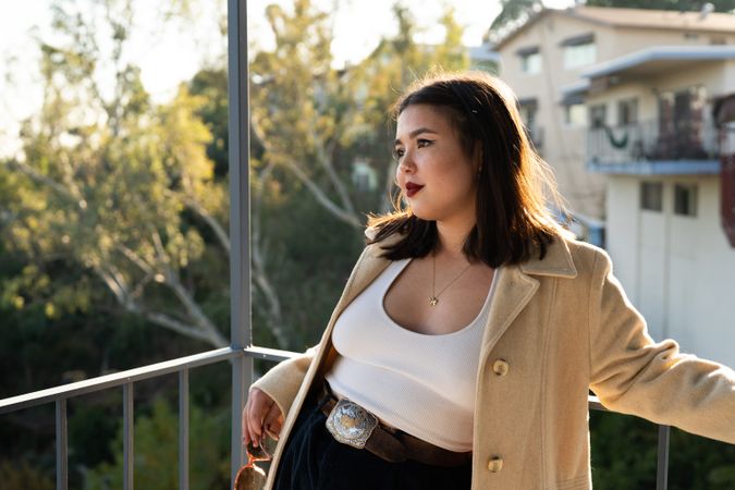 Young woman outside on patio looking into distance