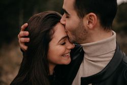 Happy couple hugging among pine forest