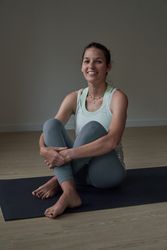 Smiling woman relaxing on mat after fitness training