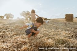 A child playing in the hay at sunset bGBpa4