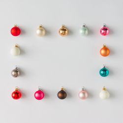 Border of colorful Christmas bauble decorations on light background
