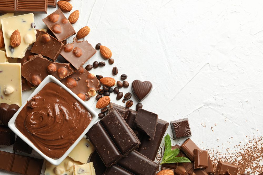 Chocolate, melted chocolate, coffee and almond on neutral background