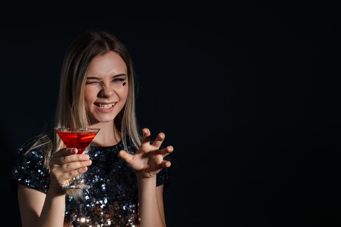 Concept of Halloween, young woman on dark background