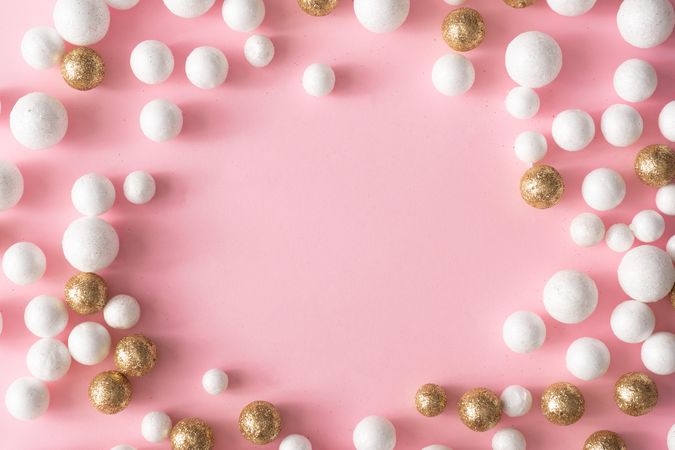 Christmas pink background with copy space made of gold and glitter ball decoration