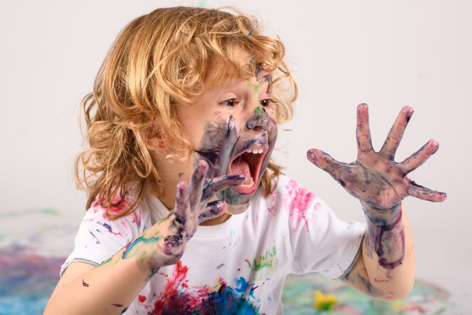 Excited boy covered with paints