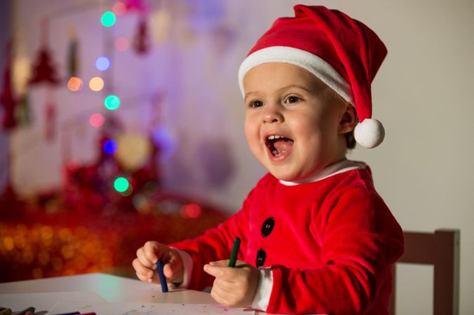 Boy in Santa hat with pencils