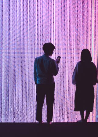 Tokyo, Japan - November 19th, 2019: Couple standing in front of full scale colorful art installation