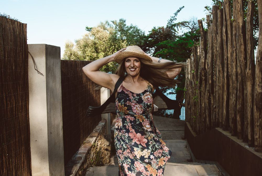 Cheerful woman in summer dress spinning around