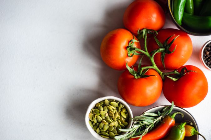 Tomatoes on the vine with seeds & seasoning on counter with copy space