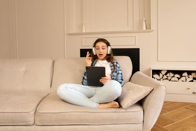 Girl having video call on tablet while wearing headphones.