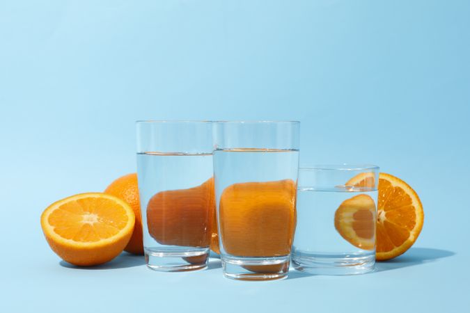 Three glass of water with orange halves