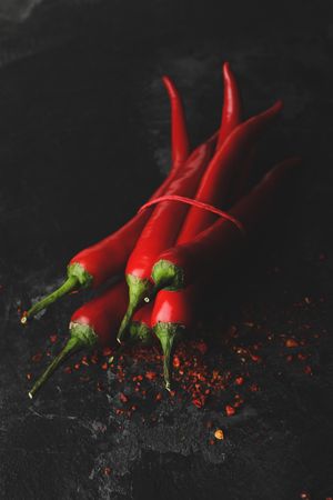 Tasty chilli peppers on dark cement background