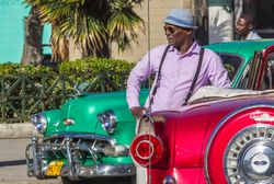 Havana, Cuba - November, 22 2012: Black man near retro cars on street