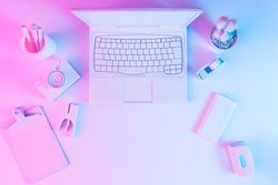 Laptop at desk with camera and stationary with vibrant bold gradient holographic lights