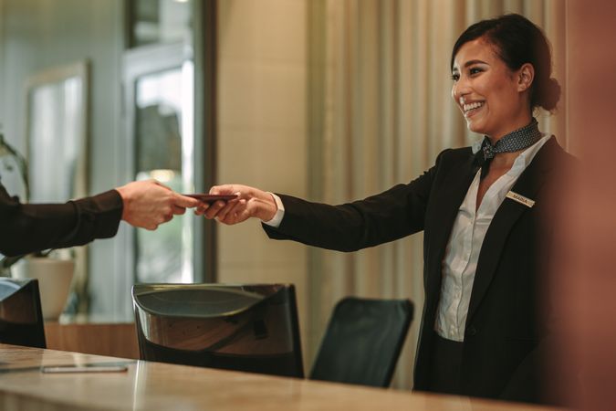 Smiling receptionist attending hotel guest