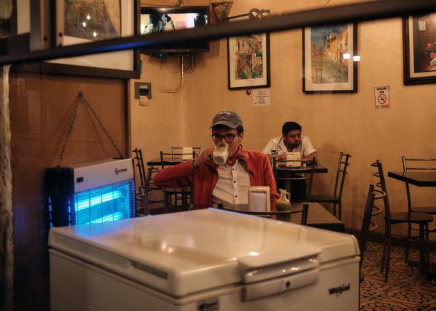 Two men sitting separately in cafe