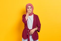 Shocked woman in red headscarf with hand over mouth