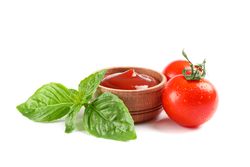 Fresh cherry tomatoes with basil and sauce isolated on studio background. Ripe vegetables