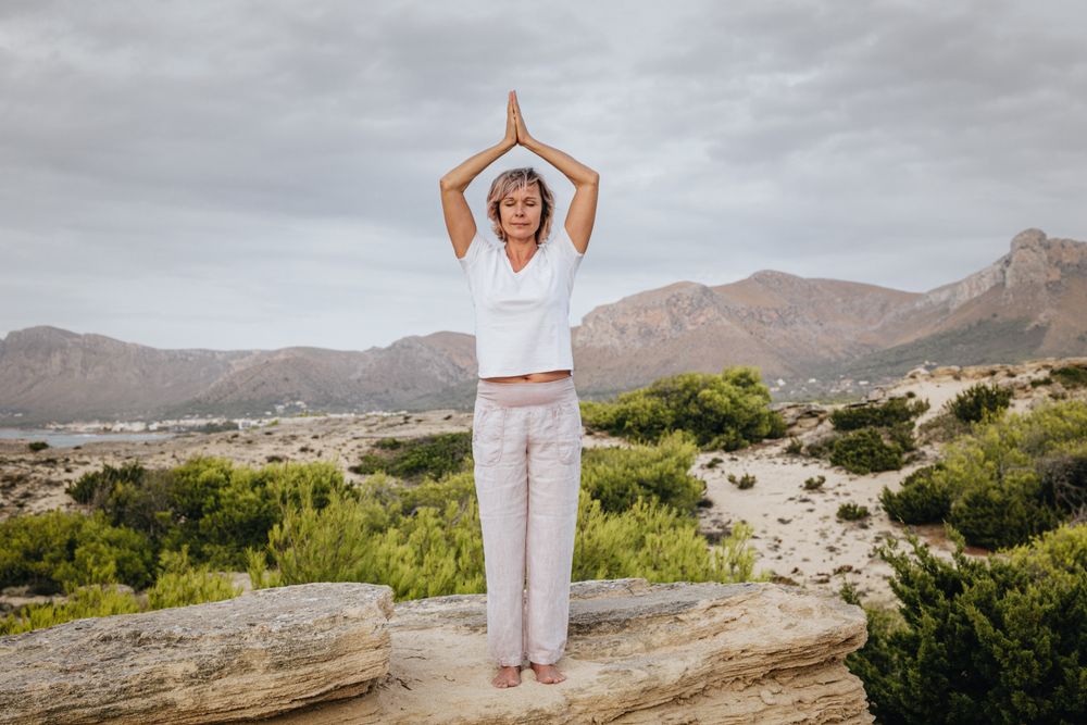 Barefoot woman meditating on stone