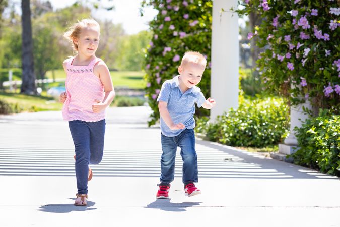 Young Sister and Brother Having Fun Running At The Park