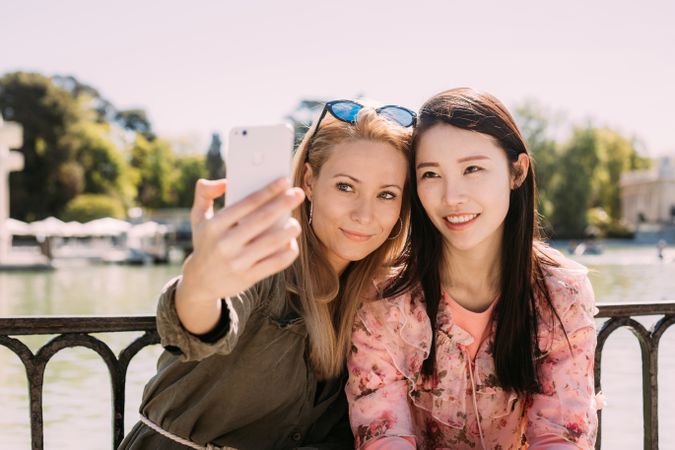 Multiethnic friends taking a selfie photo on embankment