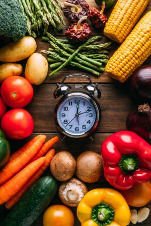Vegetables lying around alarm clock