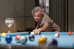 Handsome man leaning over the table while playing pool