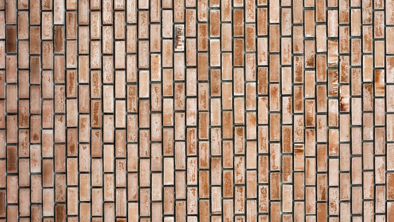 Vertical brown brick wall with geometric pattern and natural texture