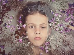 Boy lying in water with flowers
