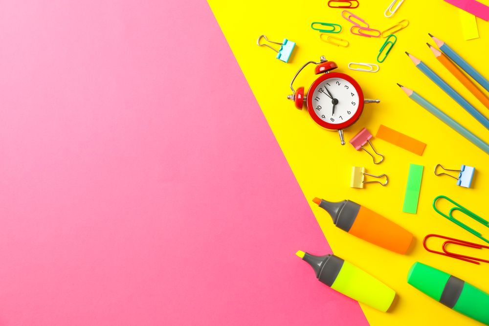 Flat lay composition with school supplies on two tone background, space for text