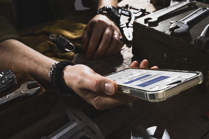 Mechanic with oily hands texting