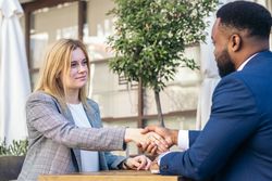 Two multiracial business people shaking hands closing a business deal