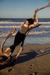 Young woman near twig and water on shore