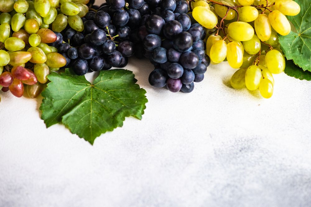 Top view of fresh red & green grapes on counter with copy space