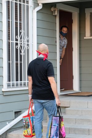 Man delivering groceries to a man at his house