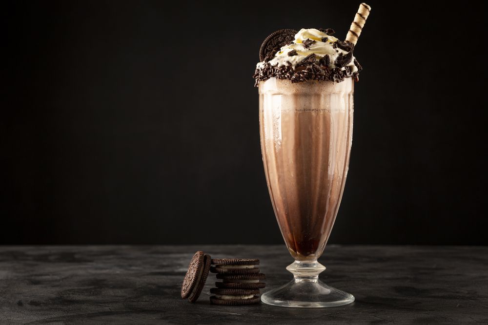 Chocolate milkshake with pieces of chocolate chip cookies.