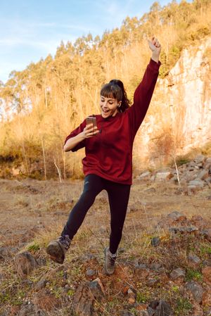 Young woman with smartphone dancing