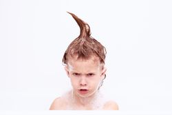 Grumpy boy with wet hair in mohawk in bathroom