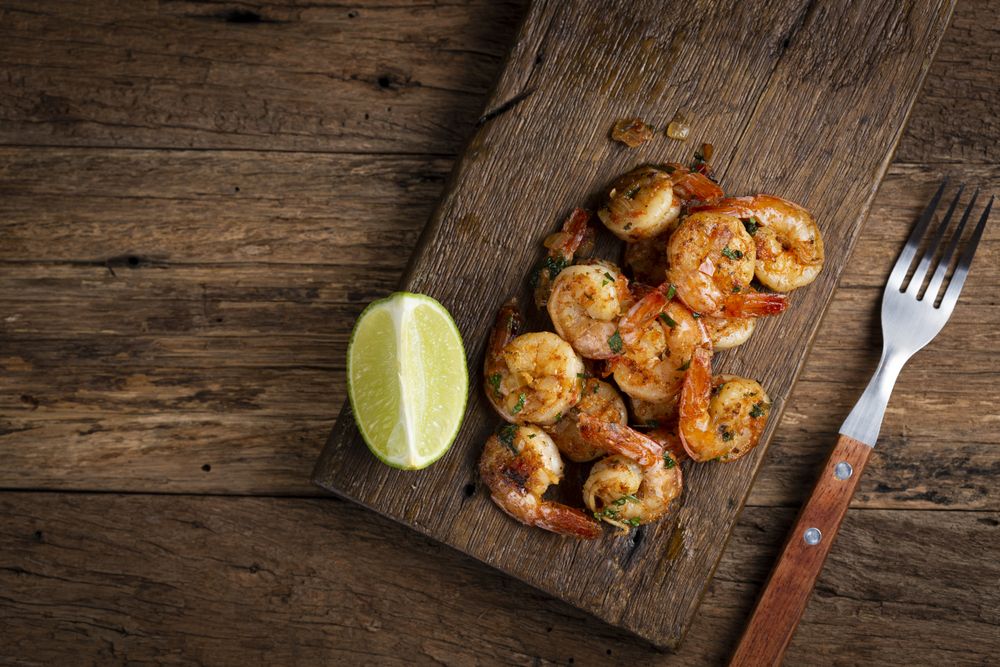 Delicious grilled prawns on wooden background.