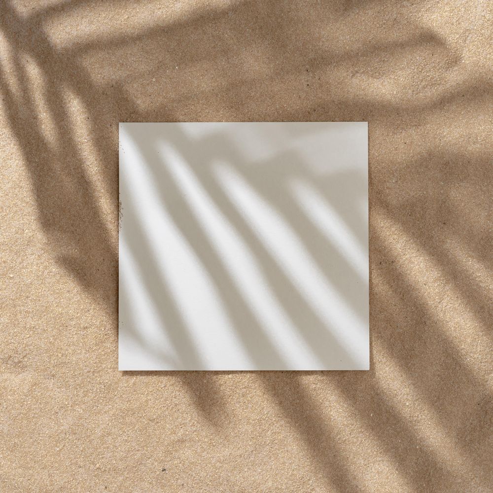 Sand with palm leaf shadows and central square