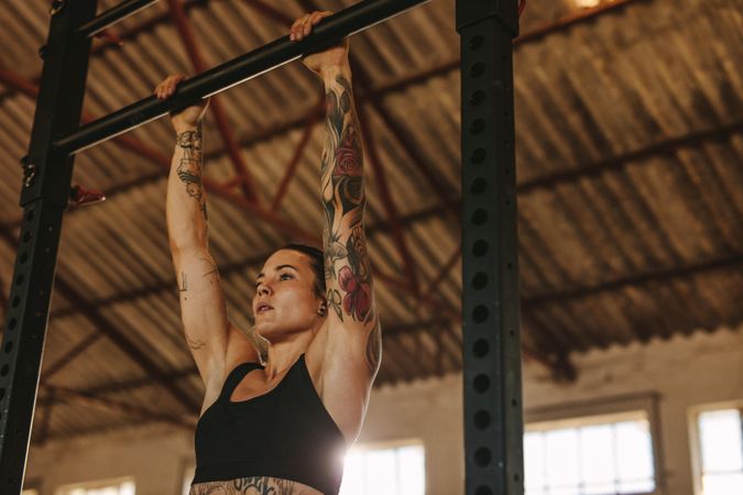 Woman doing pull up workout on horizontal bar