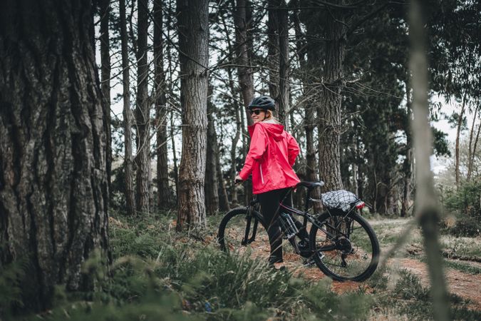 Female bicyclist riding in forest