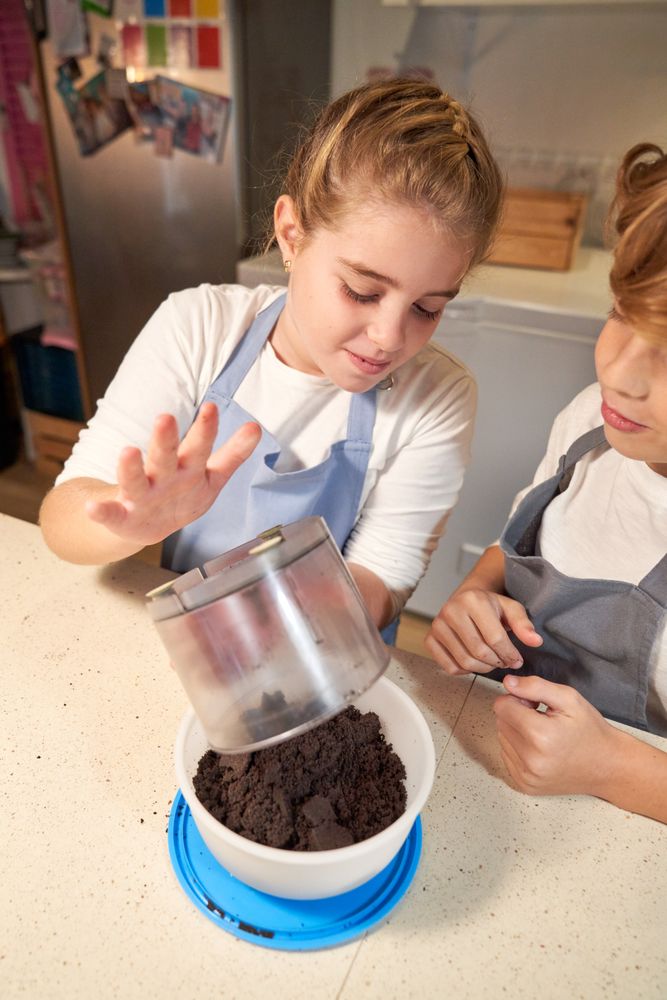 Siblings pouring crashed cookies into bowl