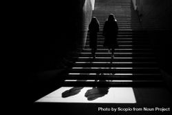 Silhouette of two people climbing stairs in grayscale 4ZwD3b